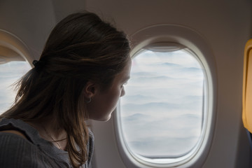 Fototapeta na wymiar Happy woman admiring the view from the window of the plane