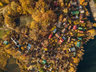 Top view from drone of small village on river bank in autumn