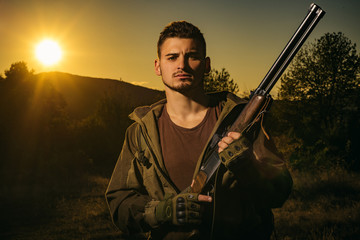 Hunter with Powerful Rifle with Scope Spotting Animals. Rifle Hunter Silhouetted in Beautiful...