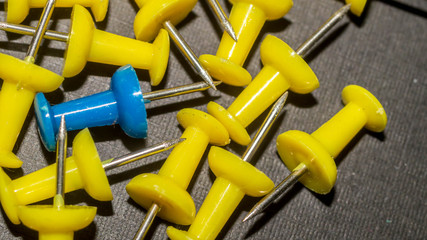 blue surrounded by yellow push pins. difference and minority concept