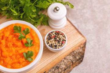 Bright tasty pureed carrot soup in clay bowl