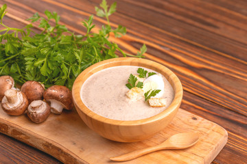 Fototapeta na wymiar Tasty pureed mushroom soup in wooden bowl with ingredients