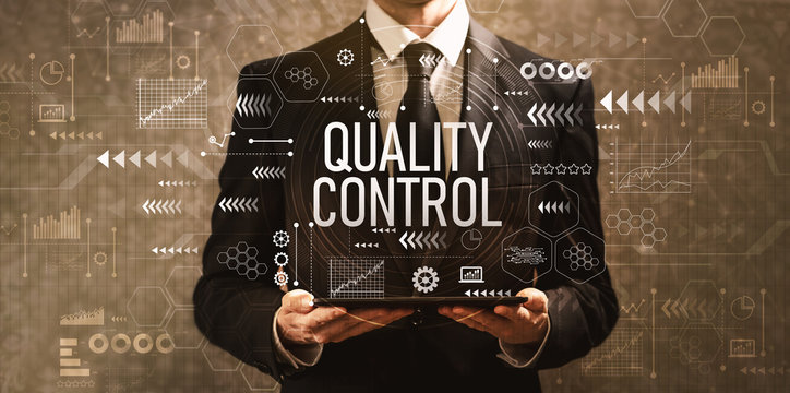 Quality control with businessman holding a tablet computer on a dark vintage background