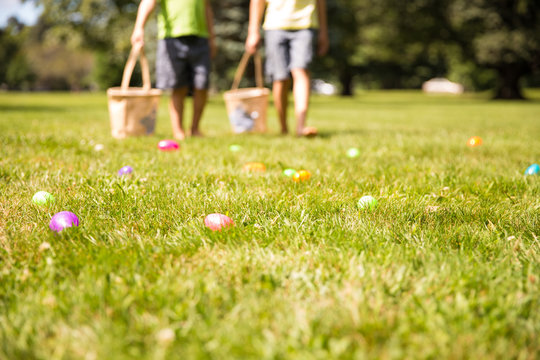 Easter Eggs Hunt. Blurred Silhouettes Of Children With Baskets In Hands. The Concept Of Family Fun At Easter.  Blurred Background. Cope Space For Your Text