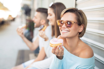 Beautiful young woman eating a donut