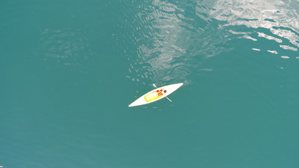 aerial top view of kayaks  over green  lake on sunny summer day