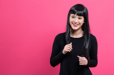 Beautiful fashionable young woman on a pink background