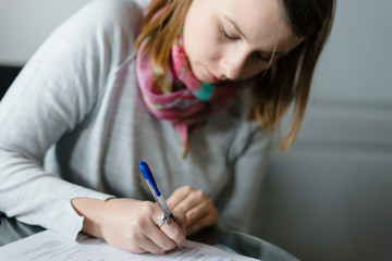 young woman writing papers