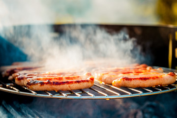 BBQ with fiery sausages on the grill outdoor picnic. Spending time together with the family at the...