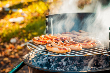 BBQ with fiery sausages on the grill outdoor picnic. Spending time together with the family at the...