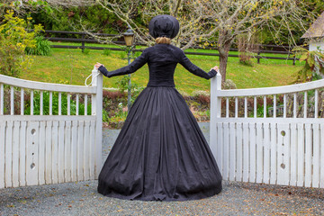 Victorian woman in black ensemble outdoors