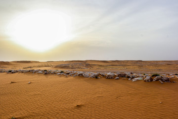 Fototapeta na wymiar Desert sand and, rocks line under sunlight.