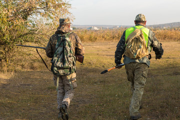 Hunters with a german drathaar and spaniel, pigeon hunting with dogs in reflective vests	