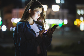 Young girl using digital tablet on night beauty light bokeh in city