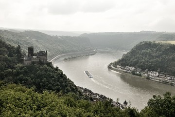 Fototapeta premium Blick von der Loreley auf dem Rhein der eine Kurve macht und auf dem ein Schlepper fährt