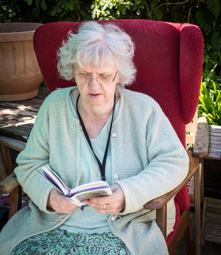 Grandma reading in the back garden, Southampton, UK