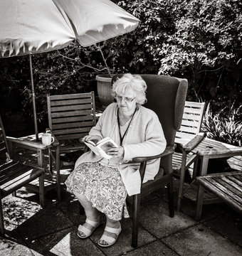 Black and White picture of grandma reading in the garden