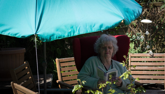 Grandma in the garden under the parasol