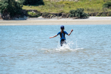 girl spashing in water as she runs to shore
