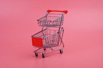 Mini shopping trolley for shopping on a pink background