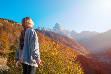 beautiful blonde girl on the background of Mount Ushba, mountains of Svaneti, Georgia