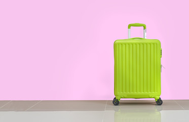 pastel colourful luggage light green on pink wall background