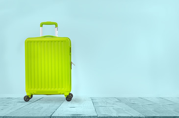 pastel luggage travel on light blue background with table top