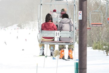 日本のスキー場とリフトに乗る男女