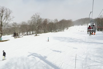 日本のスキー場とリフトに乗る男女