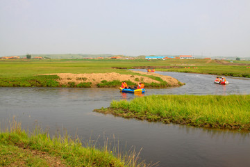Visitors paddle inflatable dinghy drift in the Tuligen River, Xilin gol league, China © junrong