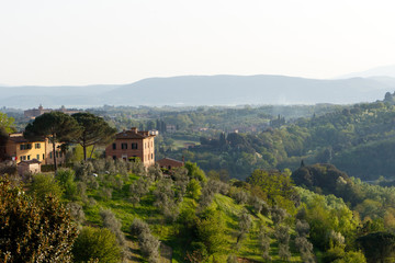 Fototapeta na wymiar Village in the Tuscan countryside as seen from Siena, Italy, located in Tuscany 