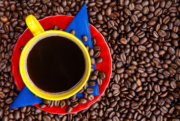 Cup of Colombian coffee and the colors of the Colombian flag over a background of roasted coffee beans