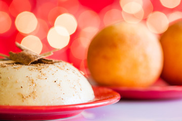 Traditional Colombian bunuelos (Deep Fried Cheese Bread) and natilla on christmas red background