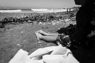 small boy's feet in the sand at the beach, in black and white