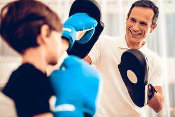 Smiling Man and Boy in Boxing Gloves in Apartment.