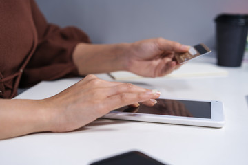 Fototapeta premium hands holding digital tablet and using laptop for online shopping