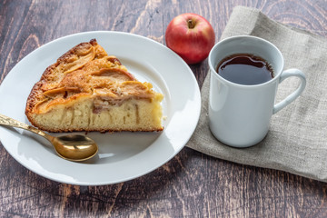 Sliced apple pie close-up on a table and tea.
