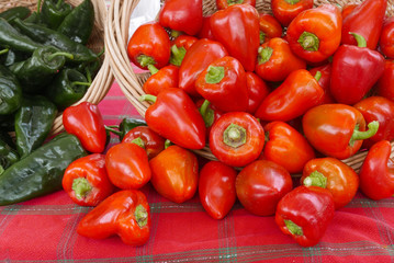 Red and green hot peppers on a red plaid tablecloth