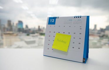 Holiday on paper note stick on the calendar of December for year end holidays concept