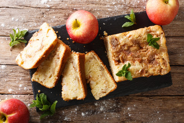 Baked sweet apple bread pie with cinnamon and mint close-up on the table. Horizontal top view from...