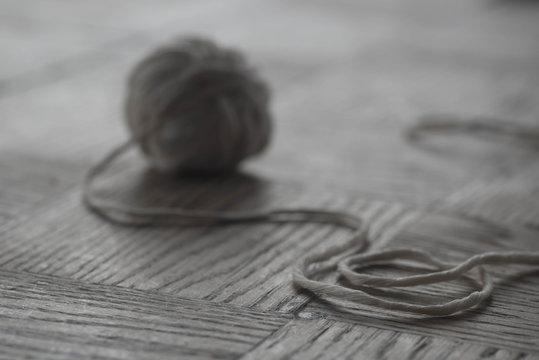 gray cotton ball of yarn on wooden  background selective focus