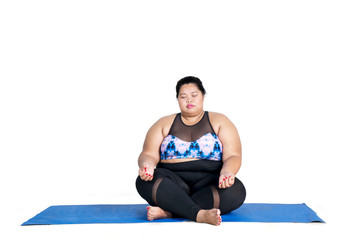 Fototapeta premium Fat woman meditating on studio
