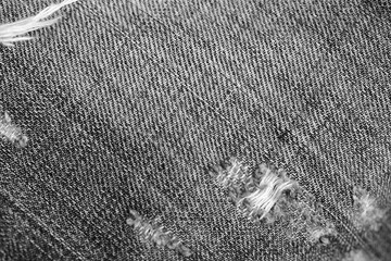 Monochrome old torn jeans texture and background close up