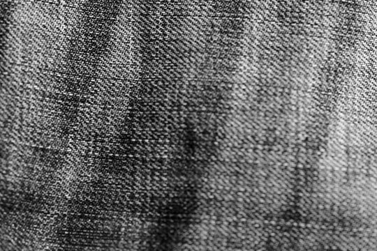 Monochrome old torn jeans texture and background close up