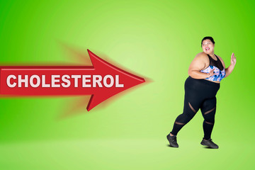 Overweight woman escaping from cholesterol word