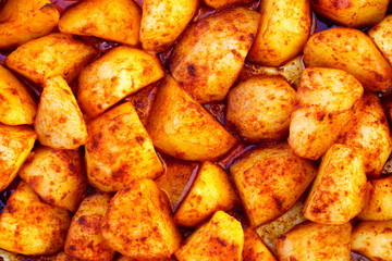 Lot of potates with red sweet pepper (paprika) as background