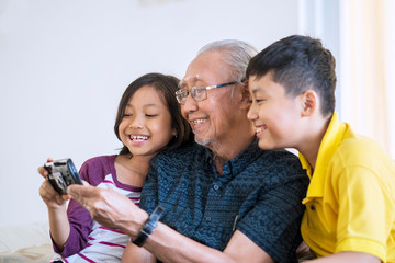 Senior man and grandchildren use cellphone
