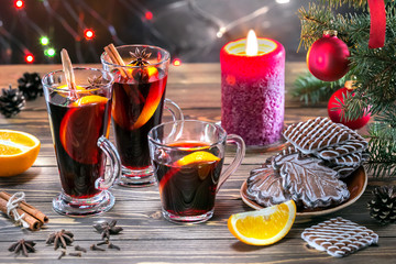 Christmas mulled red wine with spices and fruits on a wooden table. Traditional hot drink at New...