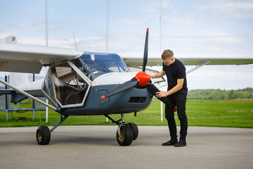 young man in small plane cockpit outdoors