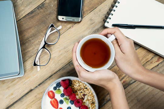 Woman Hands Holding A Cup Of Tea With Yogurt